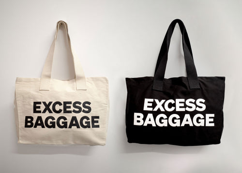 Two tote bags with 'EXCESS BAGGAGE' text on a light gray background